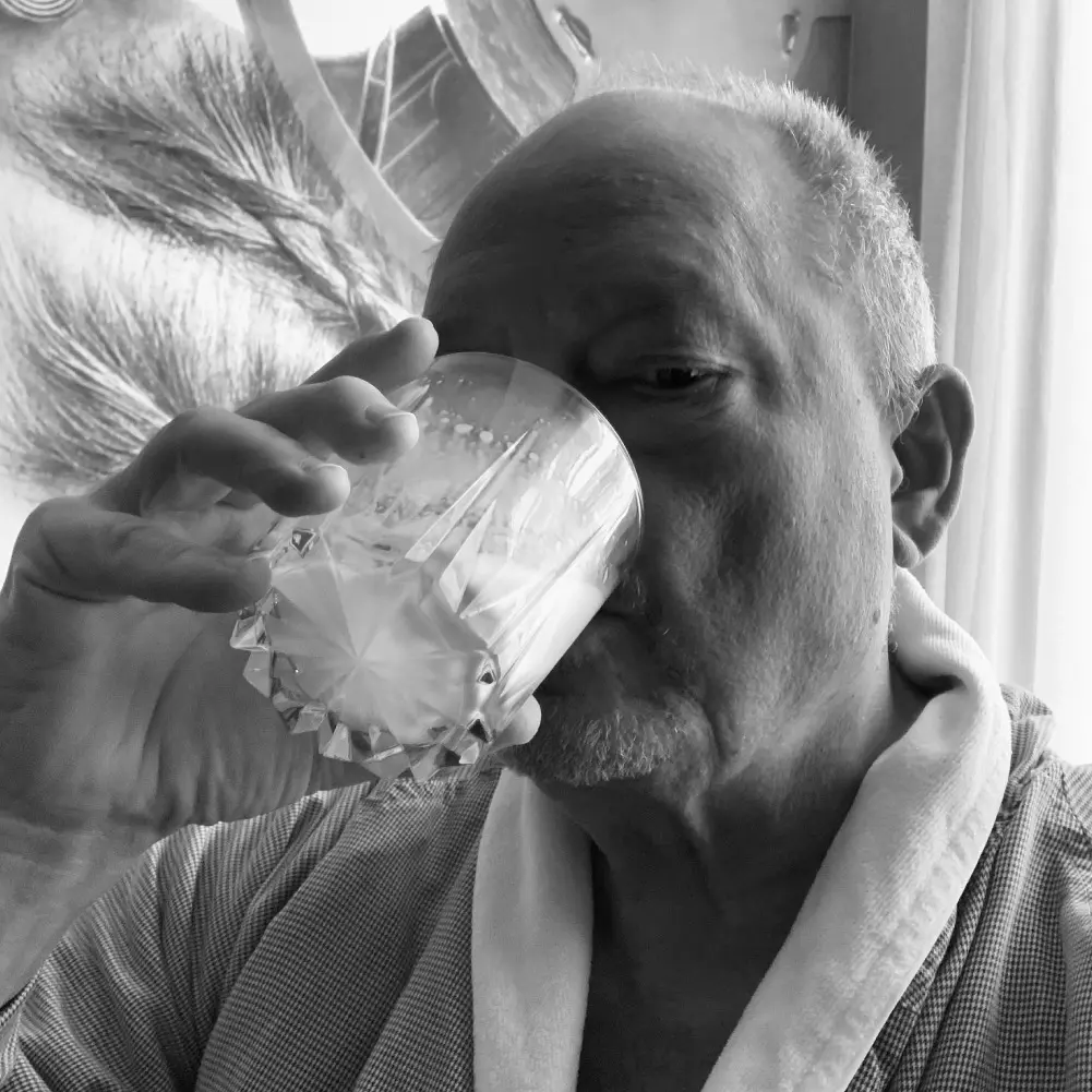 Closeup picture of a man drinking from a glass