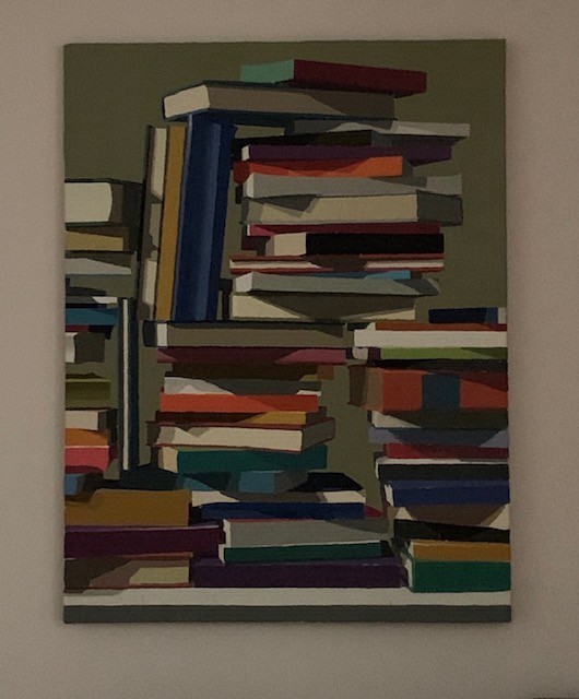 Picture of a framed painting that has a pile of books