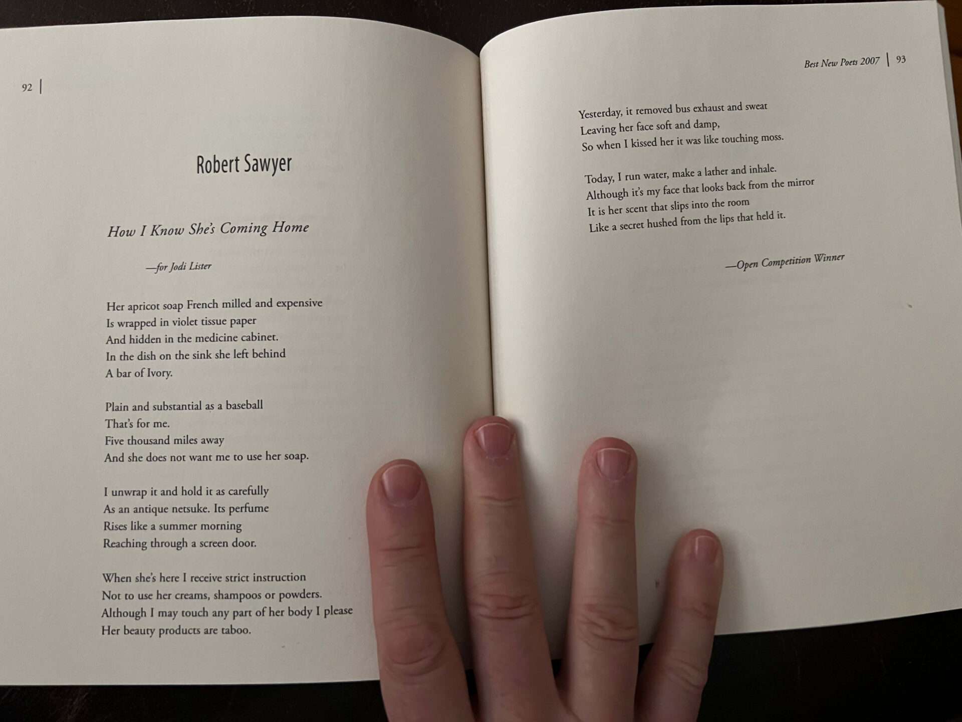 A person holding an open book with a poem in it.