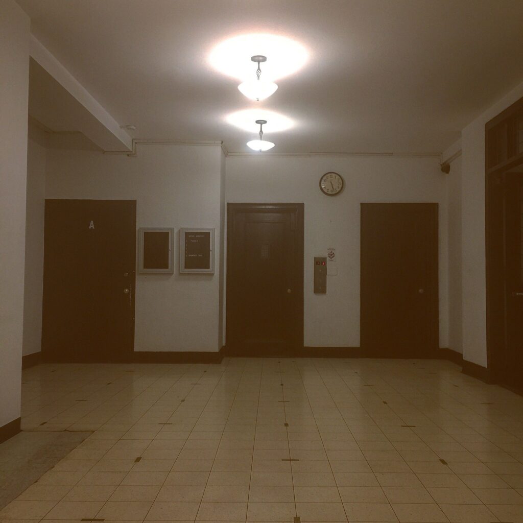 An empty hallway with two doors and a light fixture.